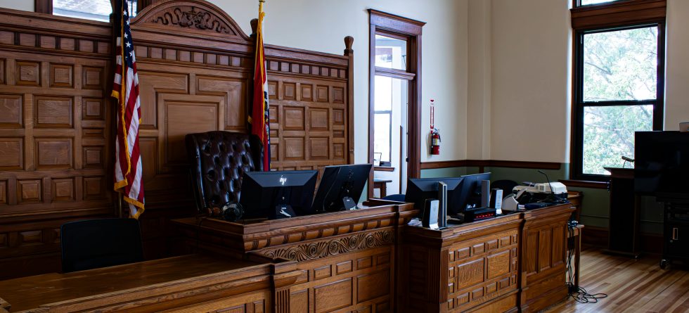 Empty courtroom in Wichita, KS with judge’s bench and American flag – representing the legal process supported by Case Bail Bonds.